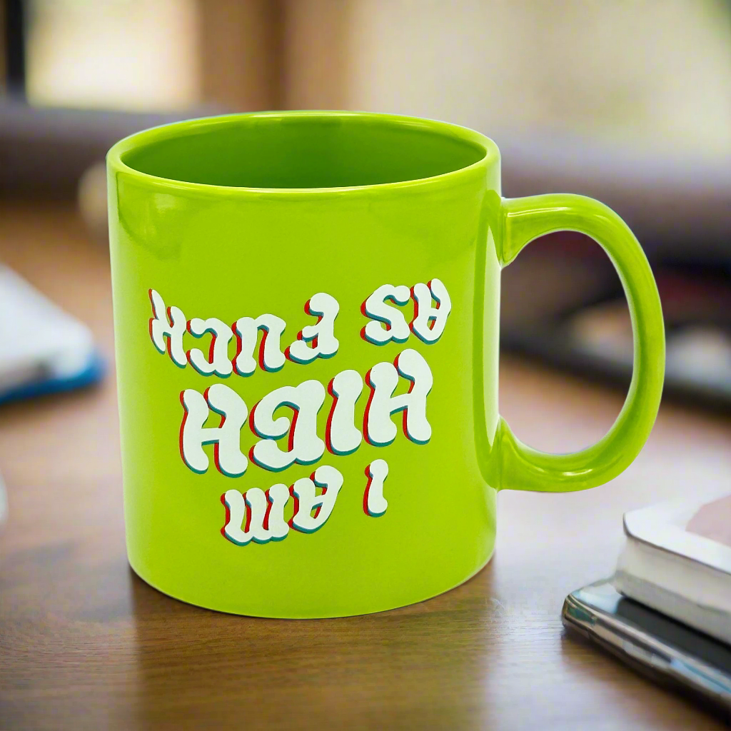 A green oversized mug with text pattern 'I am just high as fuck' printed upside down on it.