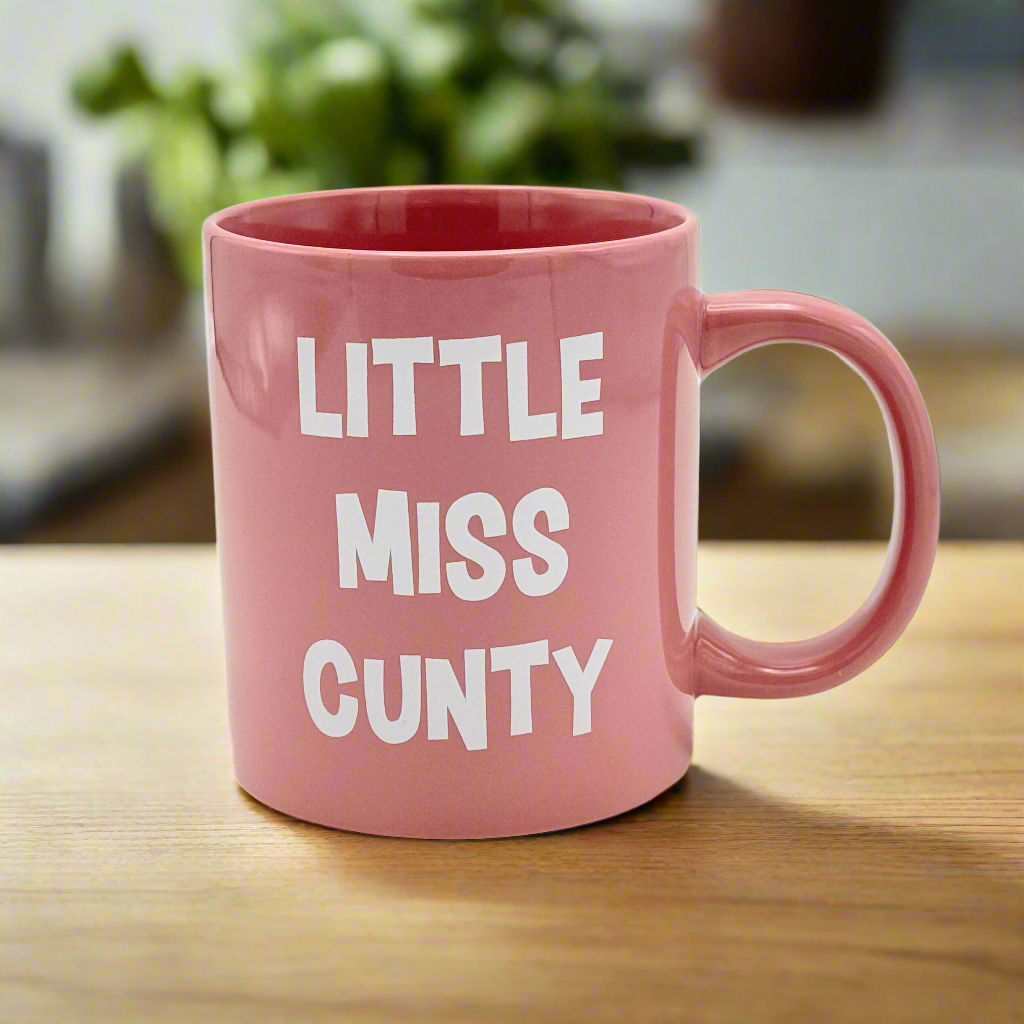 A large pink ceramic mug with the text 'LITTLE MISS CUNTY' printed in white.