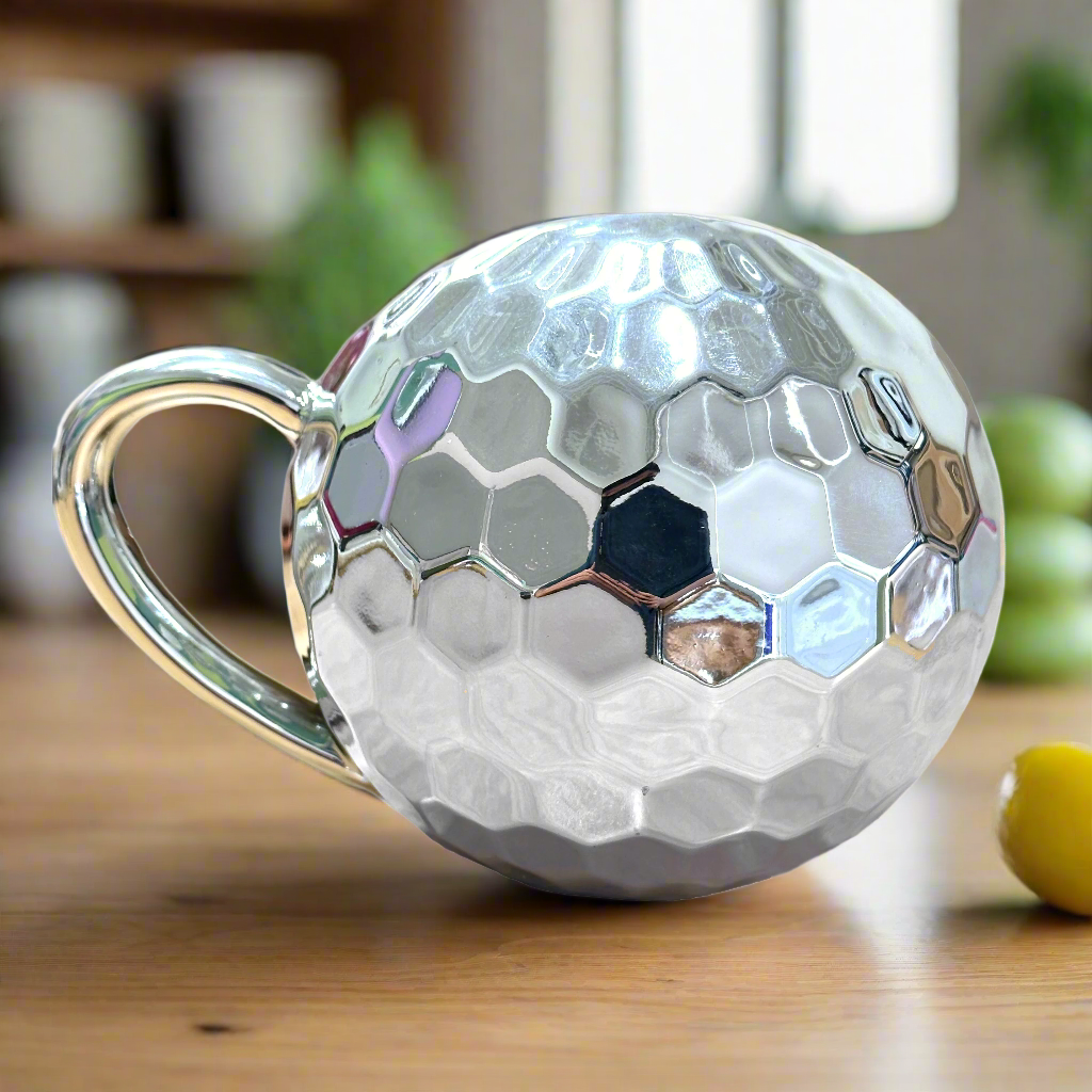 A round mug with a metallic finish and disco ball shape.